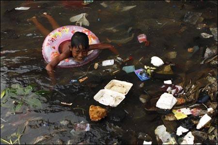 plastica negli oceani bambino-nuota-tra-rifiuti